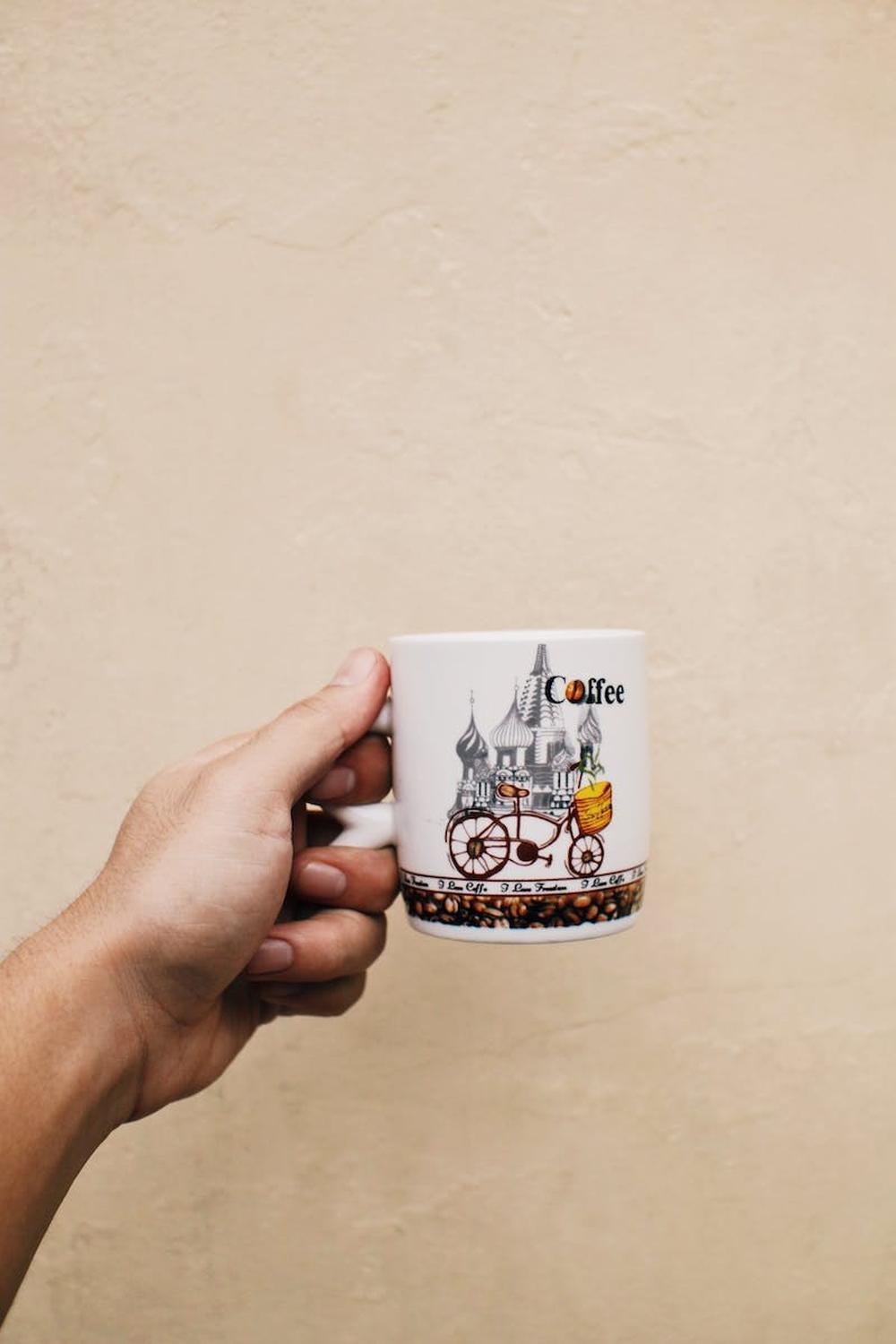  person_showing_mug_of_hot_coffee